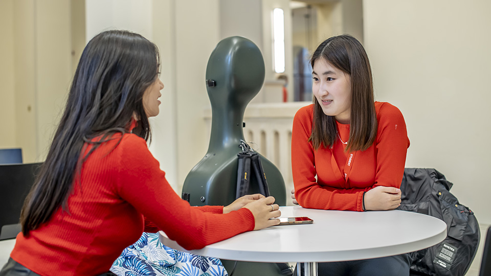Two students chatting in the RCM cafe